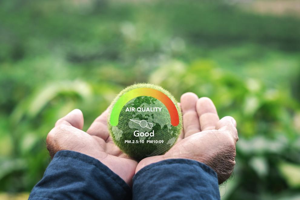 Hand protecting the earth with air quality meter concept.