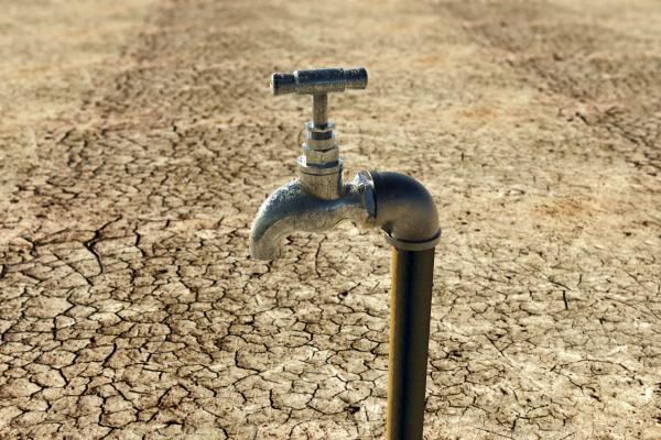 An old metal water tap in a dry surrounding